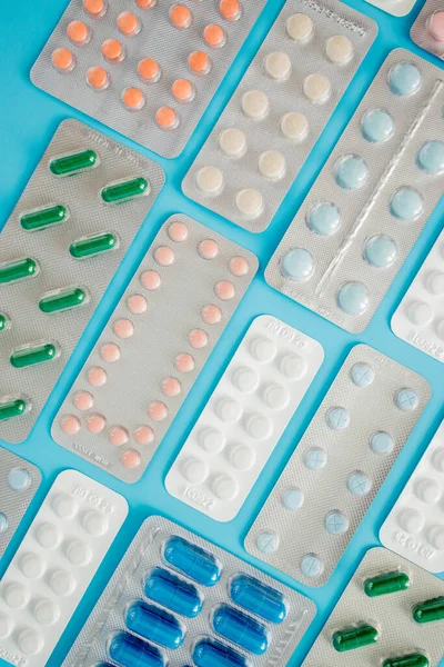 Pharmaceutical drugs, antibiotics, pills. Colorful pills on a blue background, capsule pills.