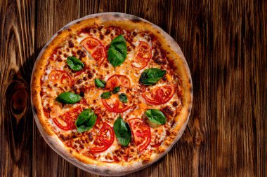 Mozarella soslu lezzetli kokulu pizza, domates ve domates soslu fesleğen. Üst görünüm.