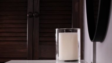 A womans hand lights scented candles with a match. Romantic dinner. On a dark background. Vertical video