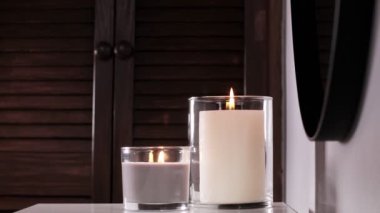 Woman puts an aroma Aroma diffuser and scented candles that create coziness in the house. Romantic atmosphere