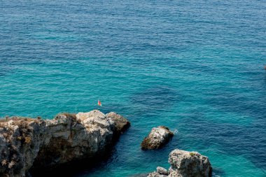 Bird's eye view of the blue sea, rocks in clear water, azure beach. Beautiful landscape of the sea coast, stones in blue water, waves