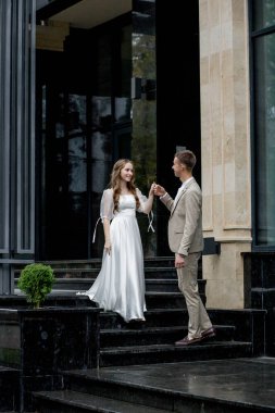 Damat, merdivenlerden inen geline elini verir. Düğün gününde çekim yapmak..