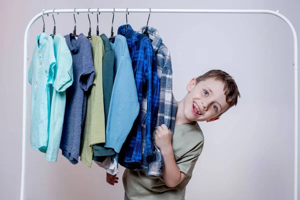 Stylish Little Smiling Preschool Boy Look Clothes Rack — Zdjęcie stockowe