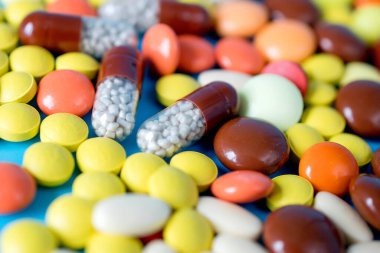 Background with the many colorful different capsules and pills. The concept of medical treatment.