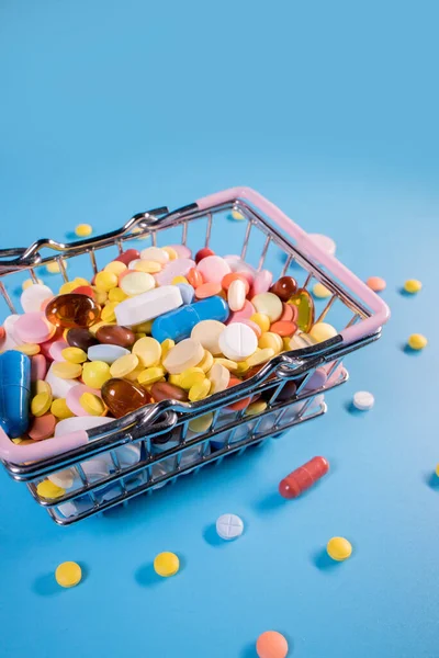 Mavi Arka Planda Alışveriş Arabasında Çeşitli Kapsüller Haplar Ilaçlar Sağlık — Stok fotoğraf