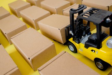 Karton kraft kutuları ve forklift kamyonu olan bir depo. Kargo sıralama kavramı.