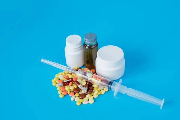 Pharmaceutical preparation, medicine in jars, pills in syringe for injection. Treatment concept.