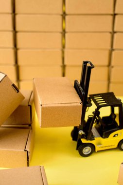 Karton kraft kutuları ve forklift kamyonu olan bir depo. Kargo sıralama kavramı.