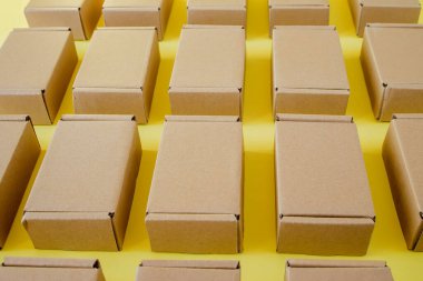 Sarı arka planda bir sürü karton kraft kutusu var. Paket paketleniyor