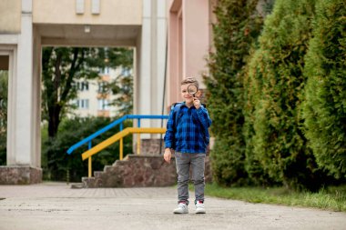 Öğrenci büyüteçle bakıyor, şaşırmış bir ifadeyle, gözlerini kısıyor..
