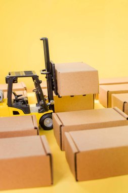 Karton kraft kutuları ve forklift kamyonu olan bir depo. Kargo sıralama kavramı.