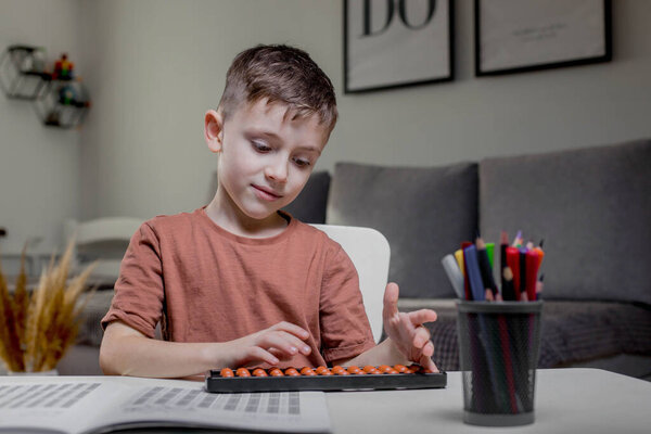 Little boy Counting with help an abacus. Mental arithmetic, brain development.