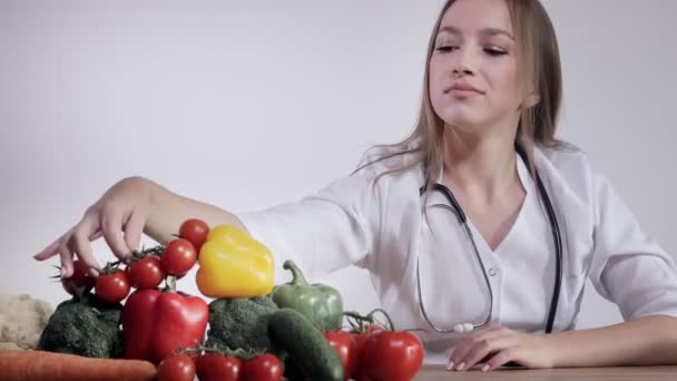 Een Vrouwelijke Arts Voedingsdeskundige Zit Aan Tafel Houdt Met Verschillende — Stockvideo