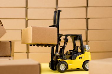 Karton kraft kutuları ve forklift kamyonu olan bir depo. Kargo tasnif ve ürün dağıtım kavramı.