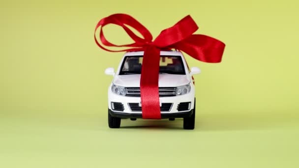 黄色の背景に弓とホワイトモデルの車 車の贈り物として — ストック動画