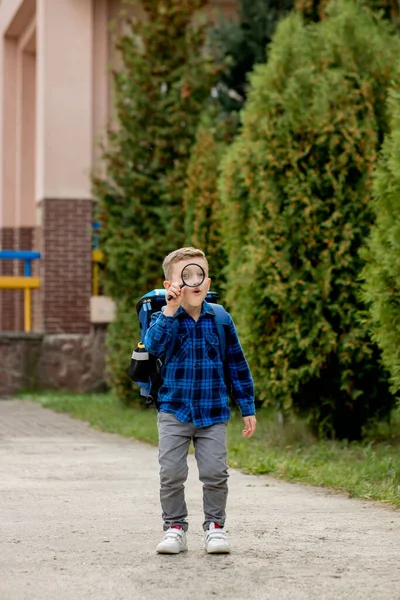 Skolpojke Tittar Genom Ett Förstoringsglas Med Ett Överraskande Uttryck Kisar — Stockfoto