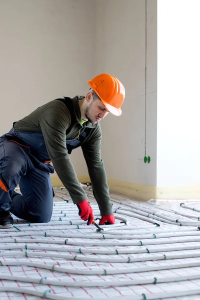 Worker is installing underfloor heating system. Warm floor heating system.