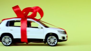 Sarı arka planı olan beyaz model bir araba. Araba hediye, sürpriz.