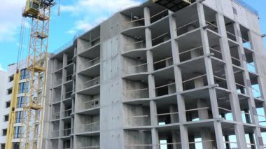 Bir şehirde inşaat halindeki yüksek apartmanın beton çerçevesinin havadan görünüşü.