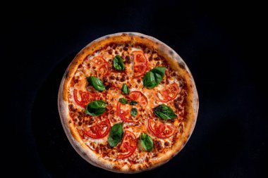 Delicious fragrant pizza with mozzarella, tomatoes and basil with tomato sauce - Margherita. Top view.