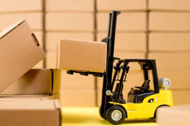 Karton kraft kutuları ve forklift kamyonu olan bir depo. Kargo sıralama kavramı.