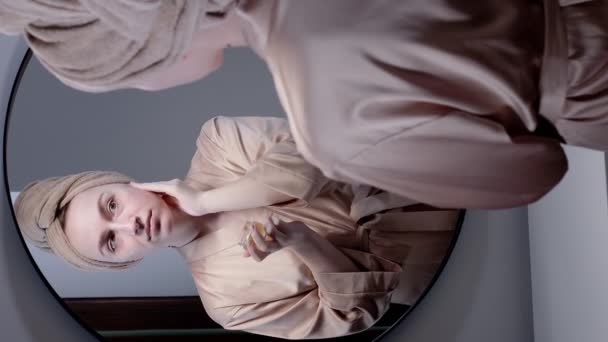 Retrato Mulher Roupão Banho Com Toalha Cabeça Aplica Creme Rosto — Vídeo de Stock