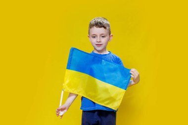 Ukrayna 'nın sarı ve mavi bayrağını tutan küçük çocuk gülümsüyor. Ukraynalı çocuk. Ukrayna 'nın Bağımsızlık Günü. Bayrak Günü.