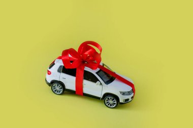 Sarı arka planı olan beyaz model bir araba. Araba hediye, sürpriz..