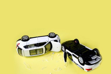 Sarı arka planda iki küçük oyuncak araba kazası, kaza, trafik kazası.