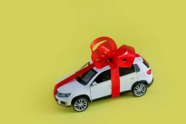 Sarı arka planı olan beyaz model bir araba. Araba hediye, sürpriz..