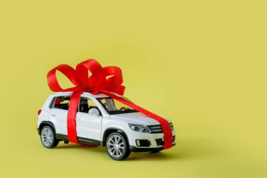 Sarı arka planı olan beyaz model bir araba. Araba hediye, sürpriz..