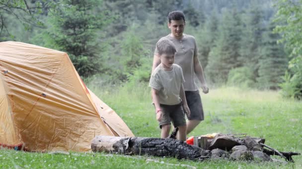 儿子和父亲正准备在大自然的烤架上烧烤 腌肉用煤块煎 在帐篷附近准备烧烤的过程 — 图库视频影像