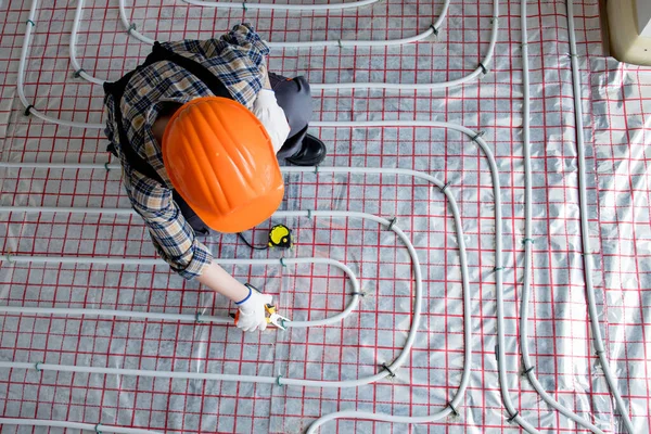 Kadın işçiler sıcak zeminin kurulumu sırasında ölçümleri alırlar. Sıcak zemin ısıtma sistemi.