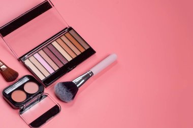 Profesyonel makyaj aletleri. Pembe arka planda makyaj ürünleri. Makyaj için çeşitli ürünler.