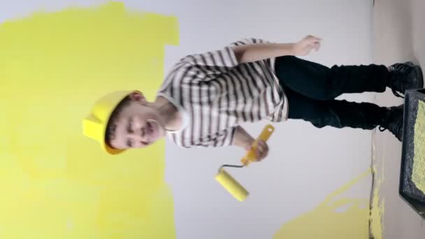 画墙时带着彩绘滚筒跳舞的可爱男孩 快乐的孩子帮助父母刷墙 家庭翻新 — 图库视频影像