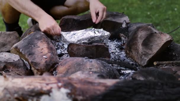 Adam Ormanın Yakınındaki Bir Ateşte Pişmiş Eti Folyo Tabağında Götürüyor — Stok video