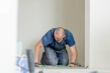 Tiler seramik duvar fayanslarını kirpik döşeme sistemi ile yapıştırıcının üzerine yerleştiriyor. Seramik Döşemeler