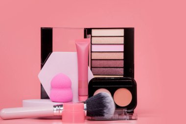 Profesyonel makyaj aletleri. Pembe arka planda makyaj ürünleri. Makyaj için çeşitli ürünler.