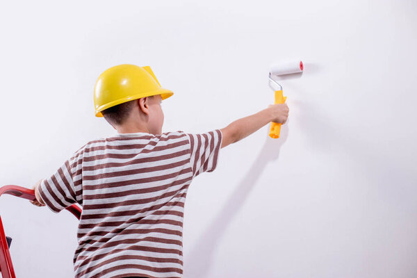 Boy painting wall during home renovation.