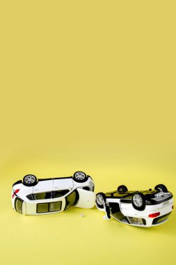 Sarı arka planda iki küçük oyuncak araba kazası, kaza, trafik kazası.