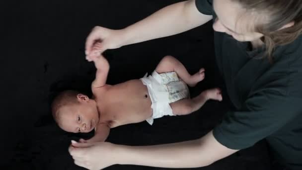 Mutter Turnt Mit Neugeborenem Das Auf Schwarzem Sofa Liegt — Stockvideo
