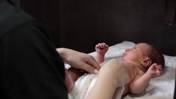 Мать Меняет Подгузник Своем Новорожденном Ребенке Помещении Маленькие Ножки Новорожденного — стоковое видео