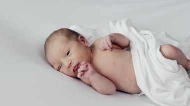 Yeni doğmuş bir çocuk ağlıyor. Yeni doğmuş bebek yatakta yorgun ve aç. Çocuklar ağlıyor. Bir çocuk ağlaması. Doğumdan hemen sonra sağlıklı küçük bir bebek..