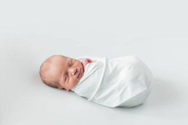 Beyaz arka planda uyuyan şirin yeni doğmuş bebeğe yakın çekim. Bakım, sevgi, mutluluk konsepti.