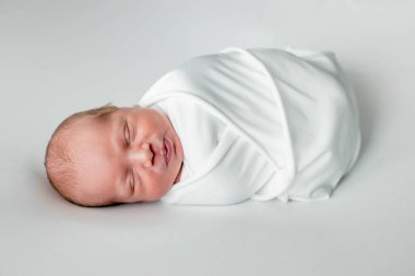 Beyaz arka planda uyuyan şirin yeni doğmuş bebeğe yakın çekim. Bakım, sevgi, mutluluk konsepti.