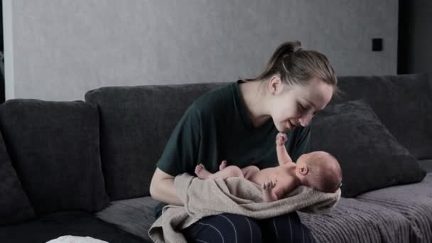 母親は新生児を抱いている 若い母親は腕を維持し 彼女の新生児を愛撫しています — ストック動画