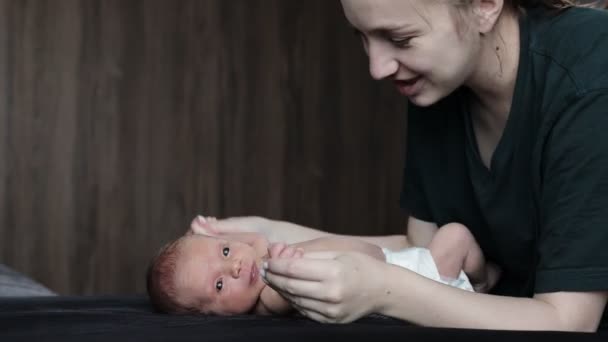 妈妈牵着新生婴儿的手 让他们慢慢地进行体操运动 可爱婴儿的父母在家里照顾他的孩子 — 图库视频影像
