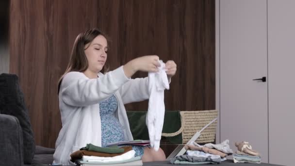 Video Einer Schwangeren Frau Die Einen Strampler Mit Kinderkleidung Faltet — Stockvideo