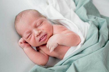 Beyaz arka planda uyuyan şirin yeni doğmuş bebeğe yakın çekim. Bakım, sevgi, mutluluk konsepti.