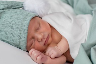 Beyaz arka planda uyuyan şirin yeni doğmuş bebeğe yakın çekim. Bakım, sevgi, mutluluk konsepti.